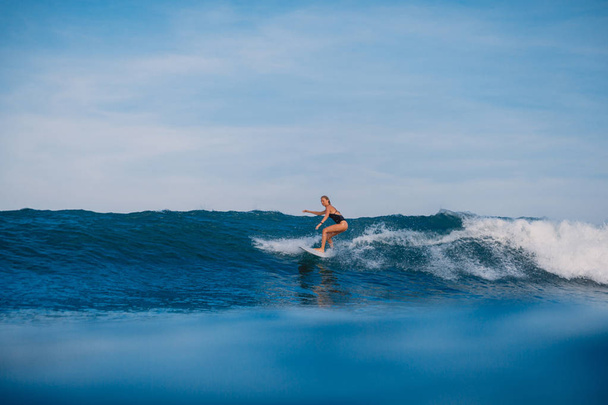 Kobieta piękna surf Wioślarstwo na deskę surfingową. Kobieta z deski surfingowej w oceanie. Surfer i ocean - Zdjęcie, obraz