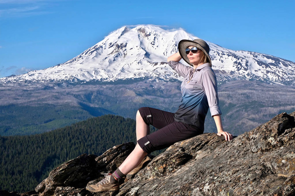 Летние каникулы в Орегоне. Женщина средних лет отдыхает на вершине горы у ледника на горе Адамс. Портленд. Орегон. Соединенные Штаты Америки
. - Фото, изображение