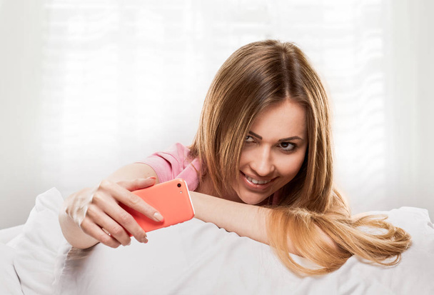 selfie girl in bed with smartphone - Фото, зображення