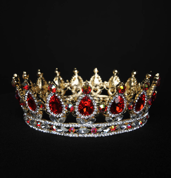 close up of red and gold crown on black studio background. - Zdjęcie, obraz