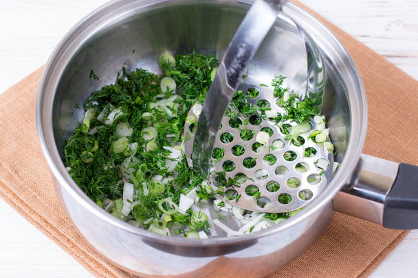 chopped green onions and dill on wooden board in a saucepan. Preparation of okroshka - Φωτογραφία, εικόνα