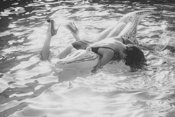 Sensual woman. brunette woman on the beach with inflatable big crocodile in the transparent blue sea. Aerial view of lady relaxing on the floating mattress - Foto, immagini