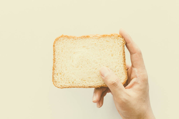 Kädet pitää viipale leipää valkoisella pohjalla
 - Valokuva, kuva
