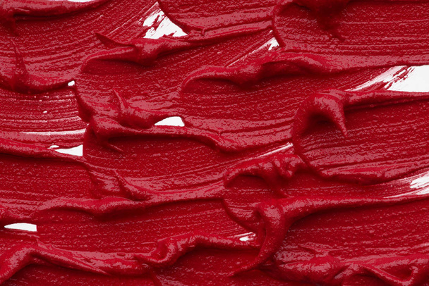 Red matte texture of lip gloss background. Red creamy lipstick texture background - Fotó, kép