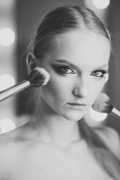 Woman face beauty. Girl makeup face with powder brushes in beauty salon. Girl skin, skincare, cosmetics. - Fotoğraf, Görsel