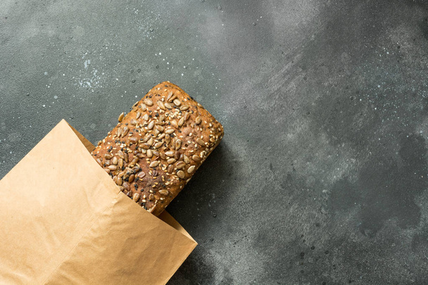 Homemade fresh rye bread with sunflower seeds on dark rural background. Close up. Space for text. - Fotoğraf, Görsel
