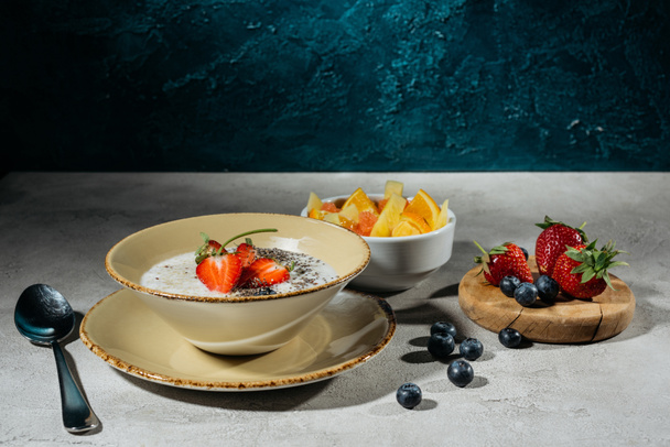 Healthy breakfast with chia seeds bowl and berries on greytable - Fotó, kép