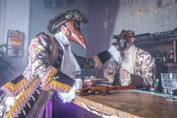 Actors in steam punk masks and antique costumes indoor. - Photo, Image