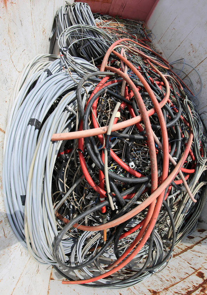 muchos cables eléctricos inutilizables en un contenedor en el sitio de eliminación de residuos
 - Foto, Imagen