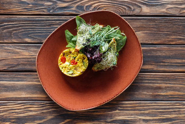 top view of vegetarian salad with sprouts and spinach on plate on wooden surface - 写真・画像