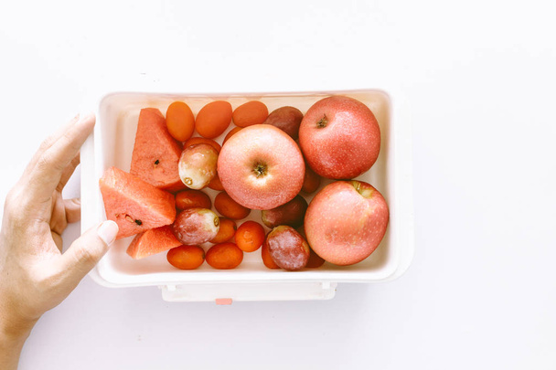 Mano con frutas frescas sobre fondo blanco - alimentación saludable
 - Foto, Imagen