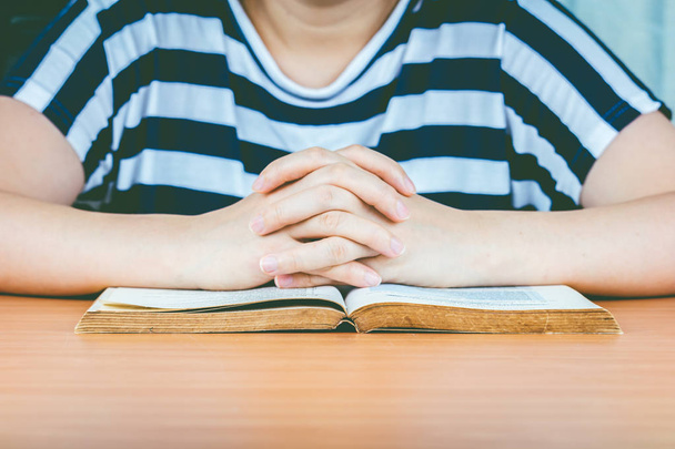Frauenhände beten mit Bibel auf Holztisch - Foto, Bild
