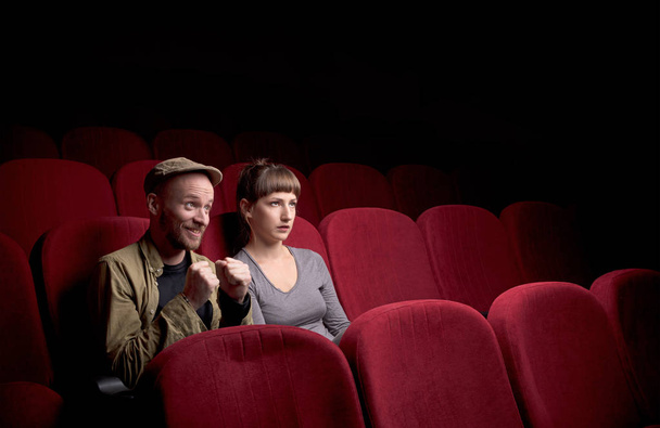 Jeune couple assis au cinéma rouge
 - Photo, image