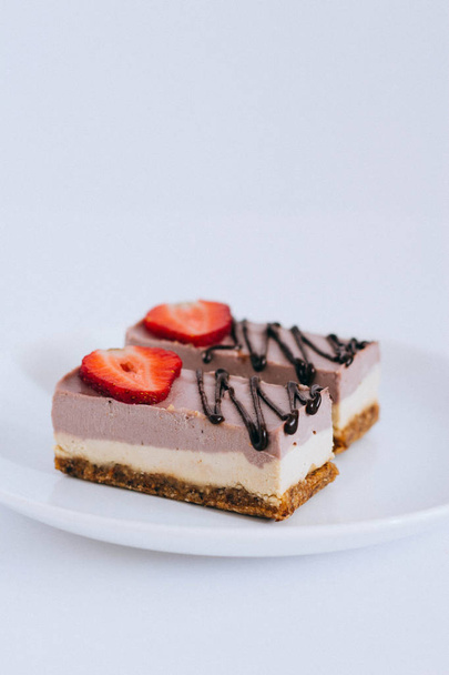ein nützliches rohes Dessert aus Nüssen und Trockenfrüchten, aus Johannisbeermousse, garniert mit Erdbeeren - Foto, Bild