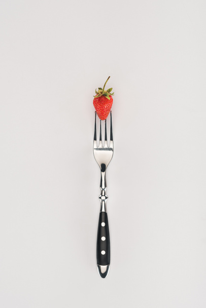 Fresa cruda sobre un tenedor aislado sobre fondo blanco
 - Foto, imagen