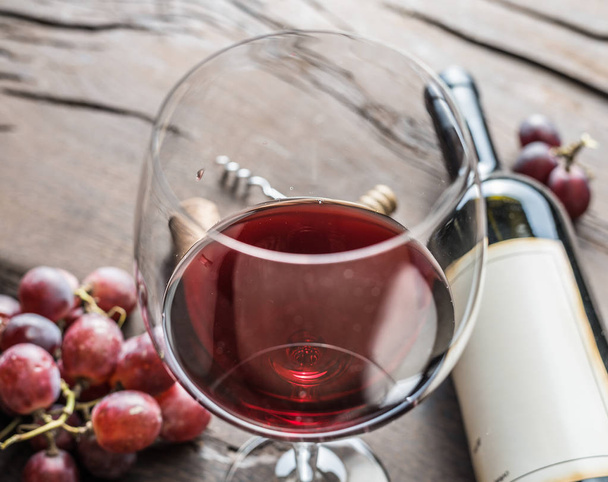 Wine glass, wine bottle and grapes on wooden background. Wine tasting. - Foto, Imagem
