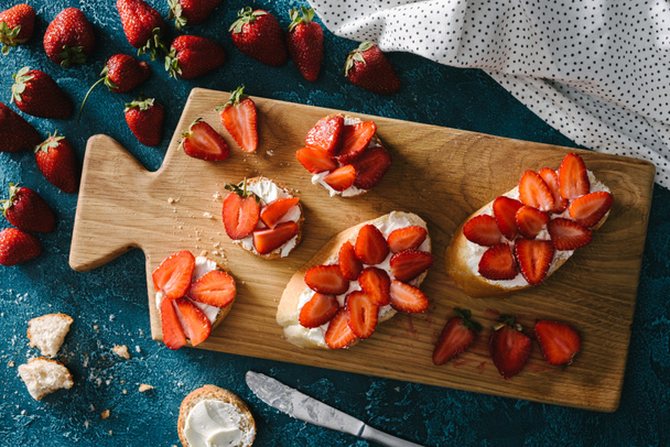 vue de dessus des fraises fraîches par planche en bois avec sandwichs d'été
 - Photo, image