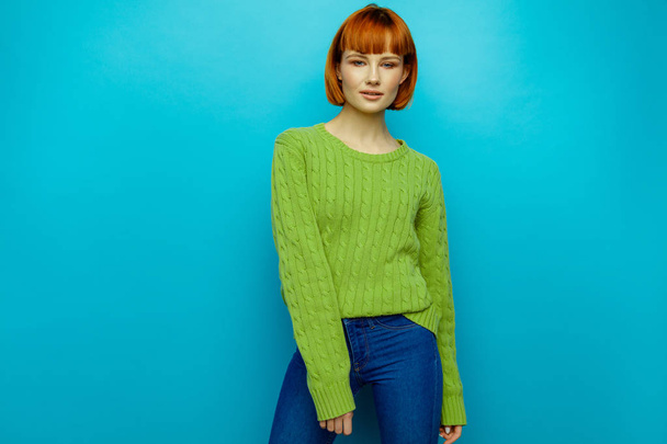 Attractive young fashion woman wear green sweater isolated on blue background - Foto, imagen