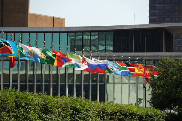 liput vilkuttaa ulkopuolella Yhdistyneet kansakunnat rakennuksen Manhattanilla New Yorkissa
 - Valokuva, kuva