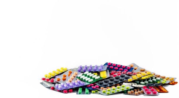 白い背景に分離されたタブレット錠剤の山。黄色、紫、黒、オレンジ、ピンク、グリーンのタブレット錠剤ブリスター パックで。鎮痛薬。片頭痛頭痛薬。医薬品業界. - 写真・画像