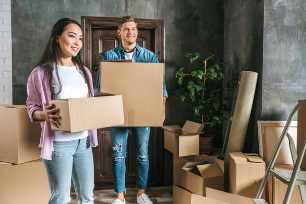 beautiful young couple with boxes moving into new home - Photo, Image