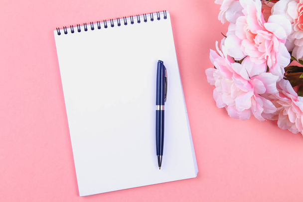 Empty notebook with blue pen on a pink pastel background. mock-up, frame, template - Zdjęcie, obraz
