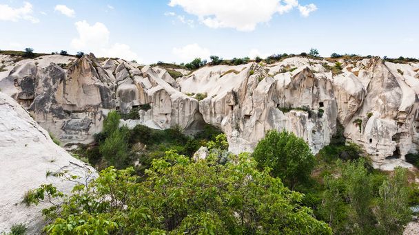 Travel to Turkey - slope of gorge with rock-cut ancient monastic settlement near Goreme town in Cappadocia in spring - Photo, Image
