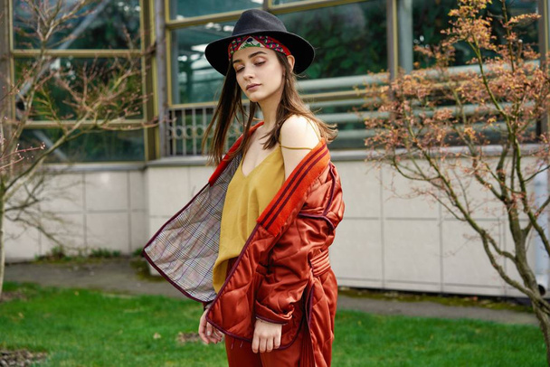 Stylish young woman wearing fashionable hat and posing outdoors - Valokuva, kuva