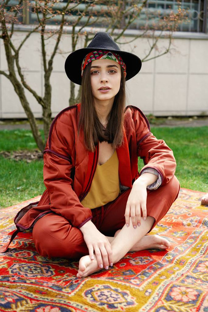Stylish young woman wearing fashionable hat and posing outdoors - Photo, image