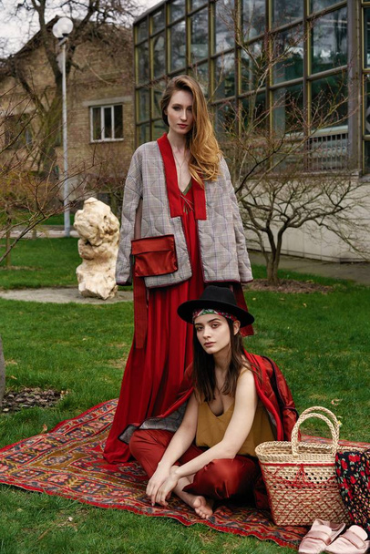 Two young female fashion models posing outdoors                - 写真・画像