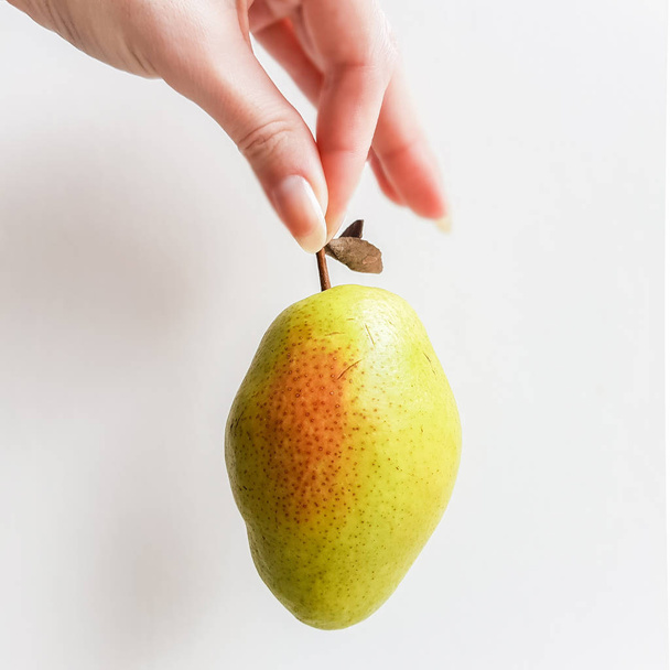 Ripe green pear in hand. White bakcground. Side view - Fotó, kép