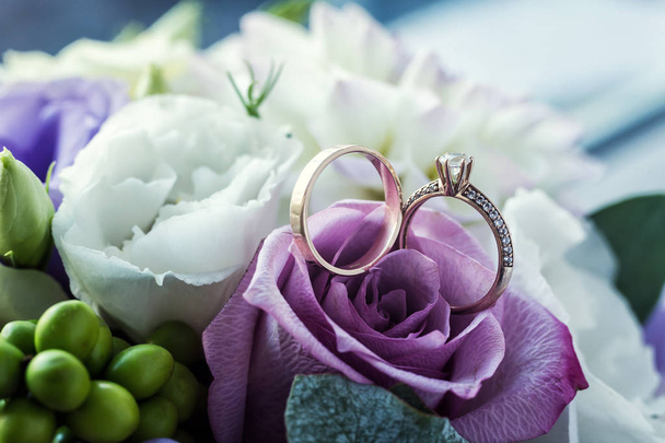 wedding rings lie on a beautiful bouquet as bridal accessories - Fotografie, Obrázek
