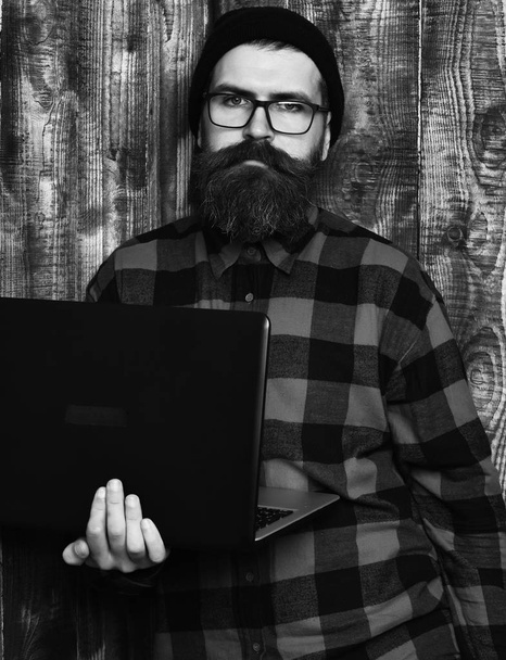 Bearded brutal caucasian hipster holding laptop - Foto, Imagen