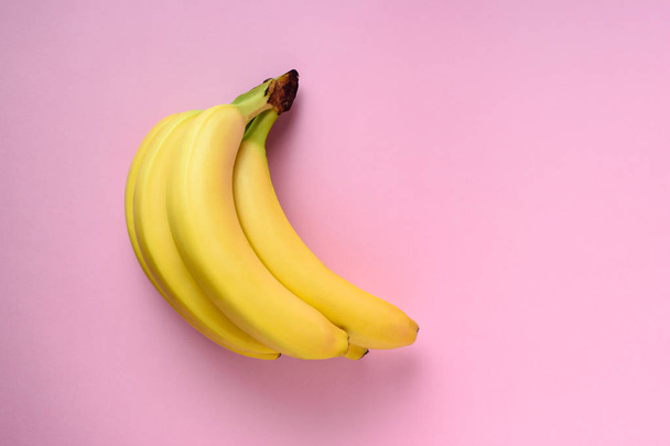 Bananas on pink background. Minimal style. Flat lay. Food concept. - Foto, afbeelding