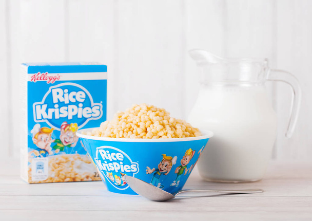 LONDON, UK - JUNE 01, 2018: Box of Kellogg's Rice Krispies Breakfast Cereal with original plate and milk on white wooden background. - Foto, imagen