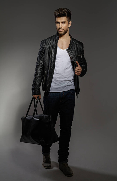Handsome man wearing black leather jacket and bag  - Фото, зображення