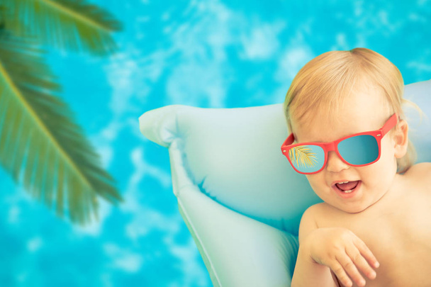 Funny baby boy on summer vacation. Child having fun in swimming pool - Фото, изображение