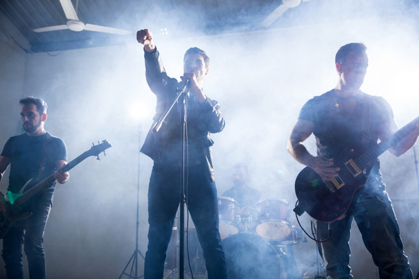 Laulaja ja kitaristit soittaa hard rock musiikkia lavalla musiikkifestivaaleilla
 - Valokuva, kuva