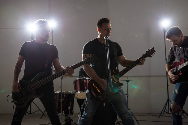 Rock bandleden gitaar spelen en zingen op muziek concert - Foto, afbeelding