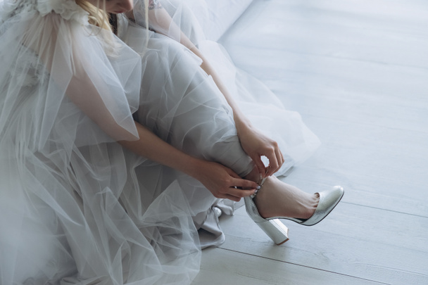 cropped shot of beautiful young bride in dress putting on shoes - Zdjęcie, obraz