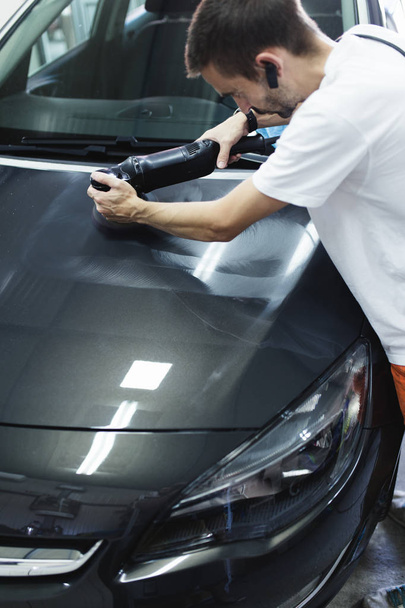 Man with orbital polisher in auto repair shop. Selective focus - Foto, Imagem