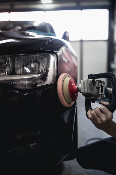 Man with orbital polisher in auto repair shop. Selective focus - Φωτογραφία, εικόνα