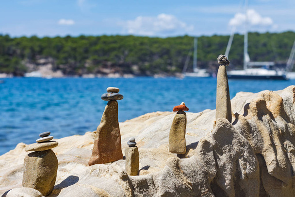 Symbolische Steinfiguren wie eine Familie am felsigen Meer. - Foto, Bild