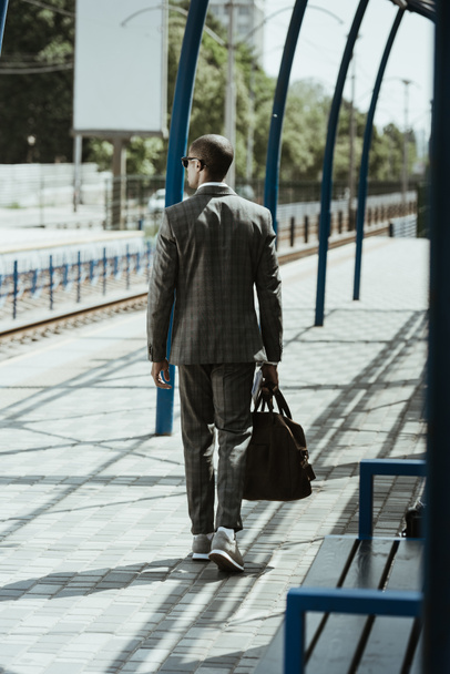 Businessman in stylish suit walking on public transport station - Zdjęcie, obraz