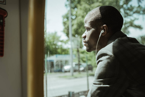 Стильний впевнений бізнесмен слухає музику під час поїздки на роботу на поїзді
 - Фото, зображення