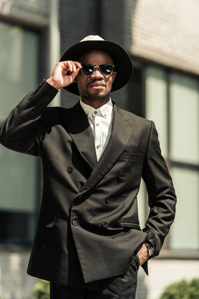 Handsome young african american businessman wearing fedora hat and sunglasses - Fotoğraf, Görsel
