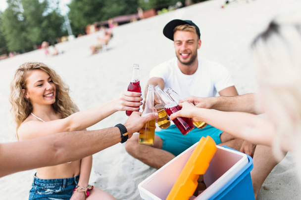 Group of attractive young people enjoying at beach, drinking and toasting. - Foto, immagini