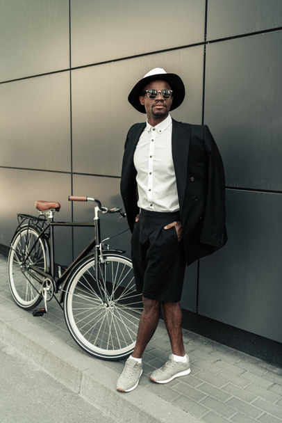 Guapo joven afroamericano posando en su bicicleta
 - Foto, Imagen