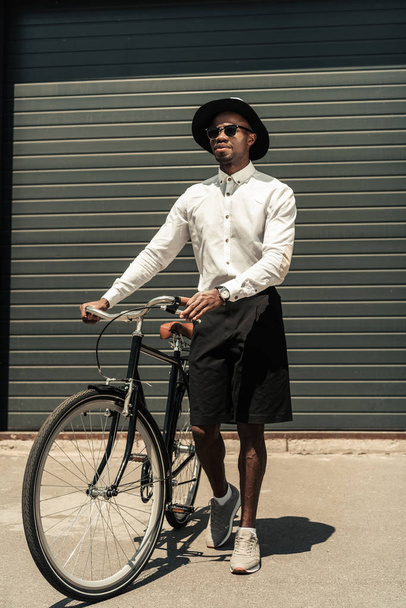 Handsome young african american man holding bike - Foto, afbeelding