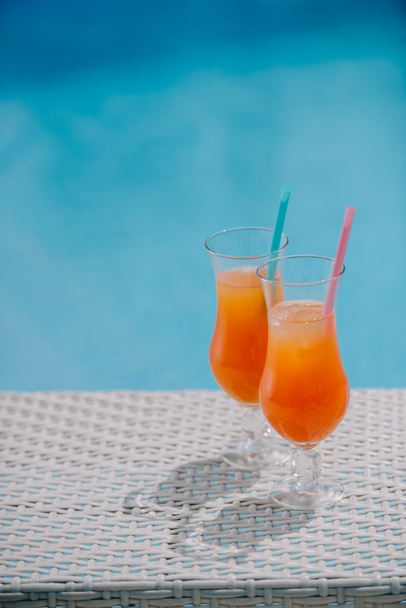 close-up view of summer cocktails with drinking straws at pool - Zdjęcie, obraz